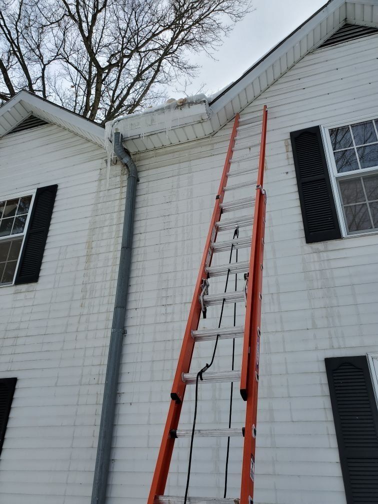 Ladder going up the side of the house to get to the roof.