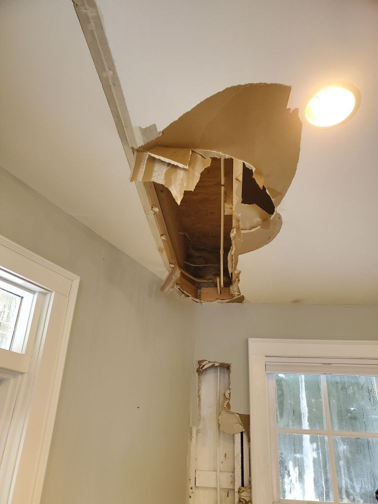 A ceiling with a hole in it that has been damaged by water. 