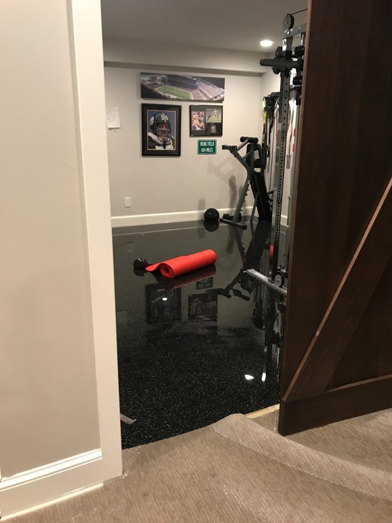 A flooded basement with a red towel laying on the floor.