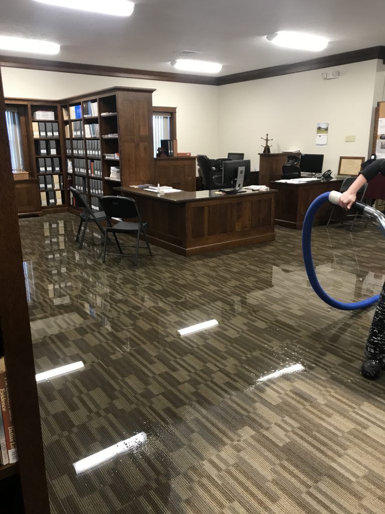 A person is using a vacuum cleaner to clean the floor of a room.