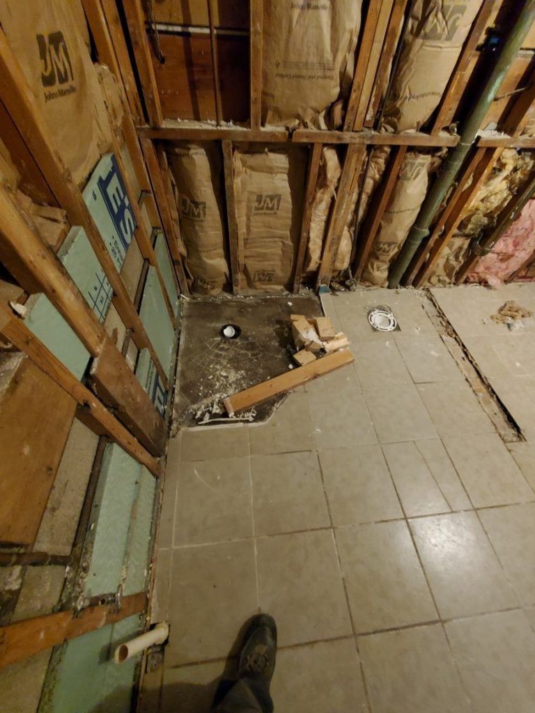 A person is standing in a room with a hole in the floor.