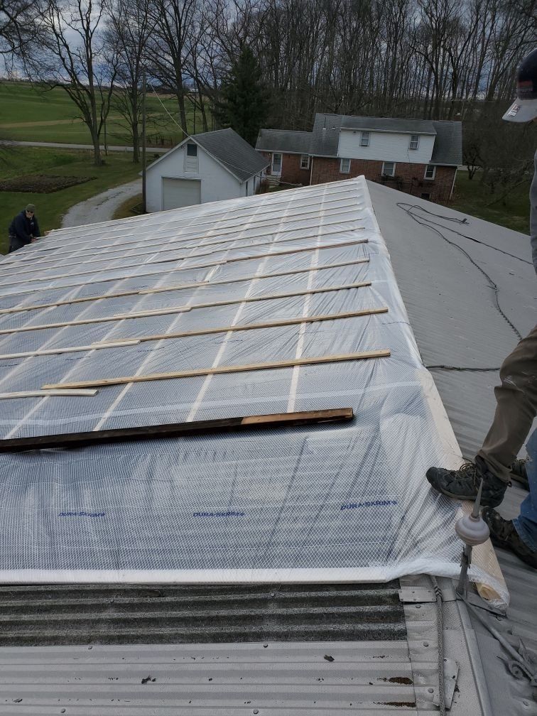 A man is working on the roof of a house.