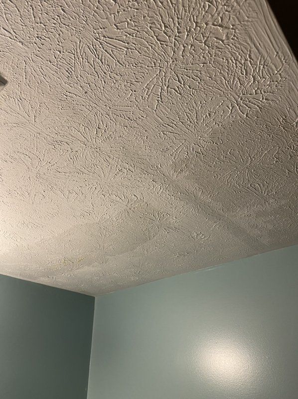 A close up of a fire damaged ceiling in a room with blue walls.