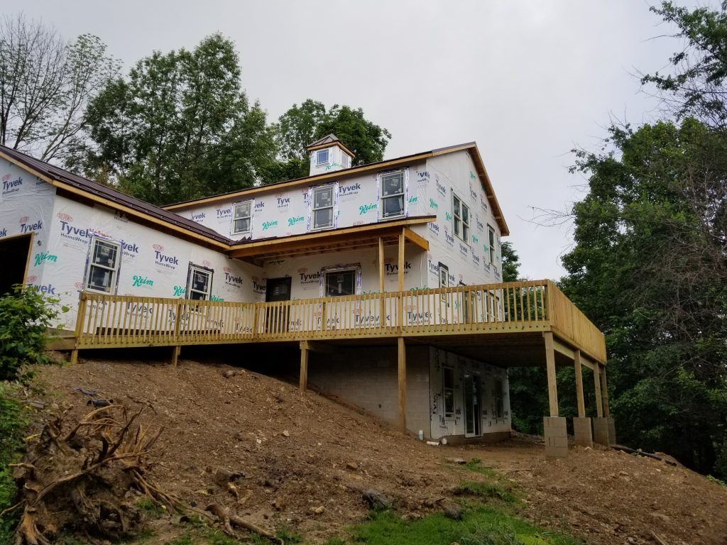 A house is being built on a hill with a large deck.