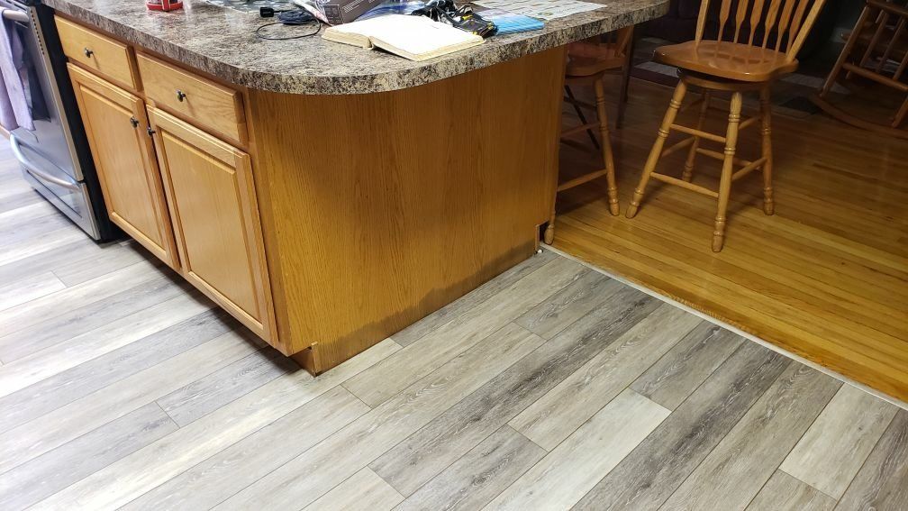 A kitchen with an island and a wooden chairs.