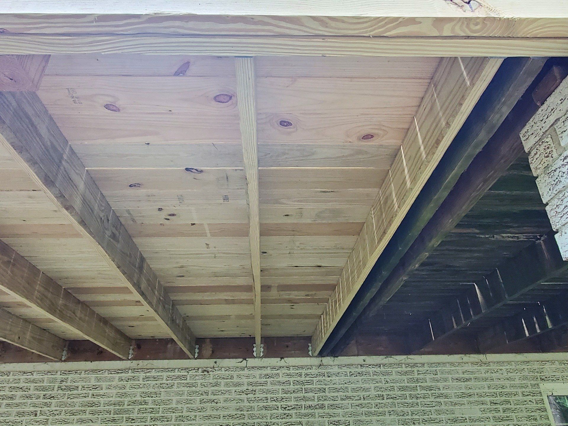 Underneath of a wooden deck on a house.