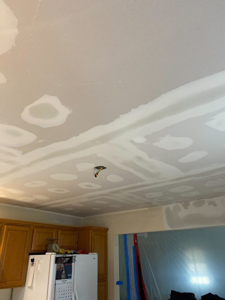 A kitchen with a white refrigerator and a white ceiling.