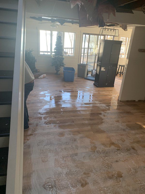 A living room with a flooded floor and a christmas tree in the background.