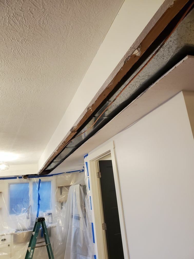 A ladder is sitting in a room with a ceiling that is being remodeled.