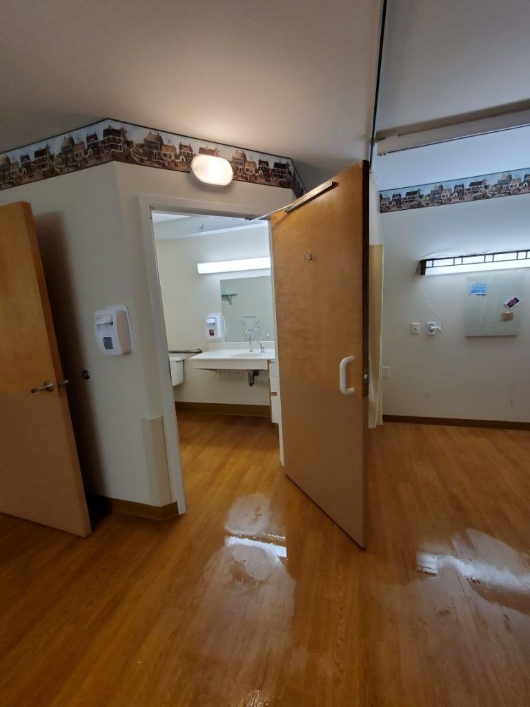 A bathroom with a sink and opened door.