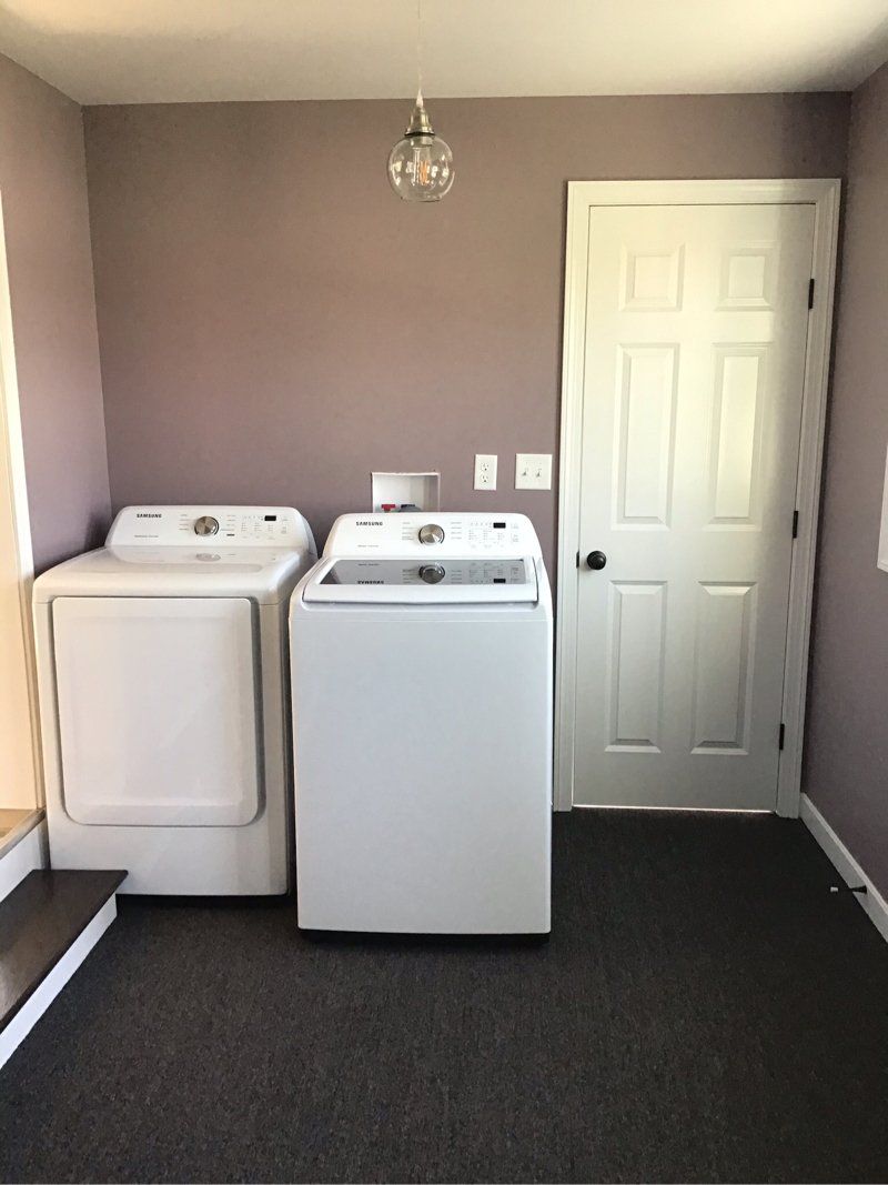 A laundry room with a washer and a door.