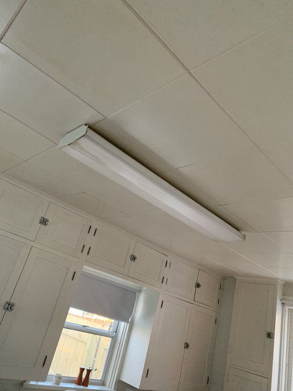 A kitchen with white cabinets and a light on the ceiling.