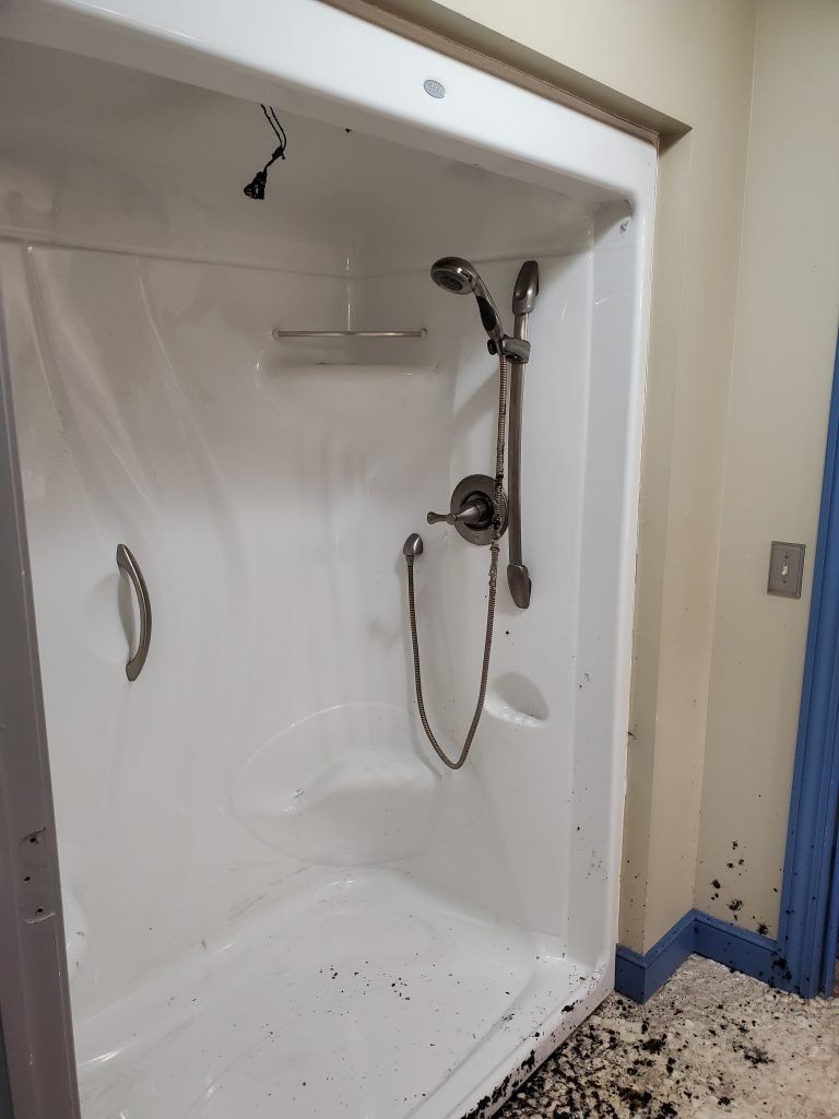 A bathroom with a shower stall and a shower head.