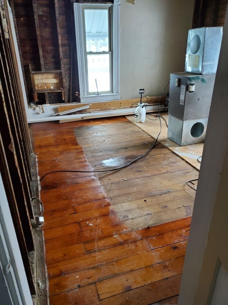 A room with a wooden floor and a window.