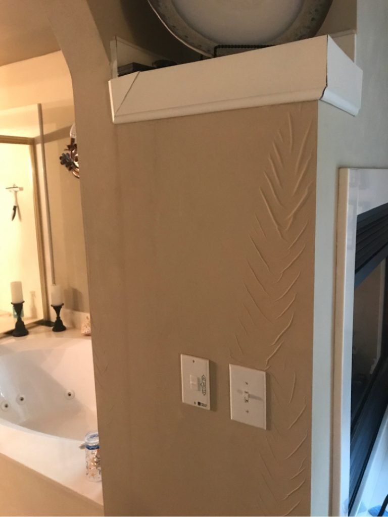 A corner of a room with a fireplace and a bathtub.