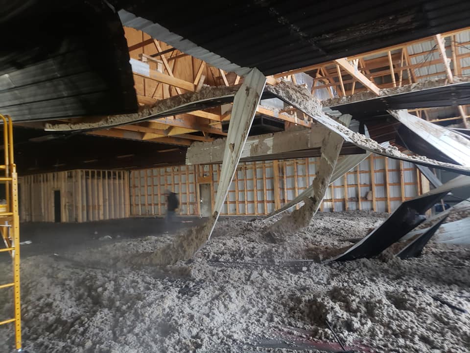 A room that is being repaired has rubble falling from ceiling.