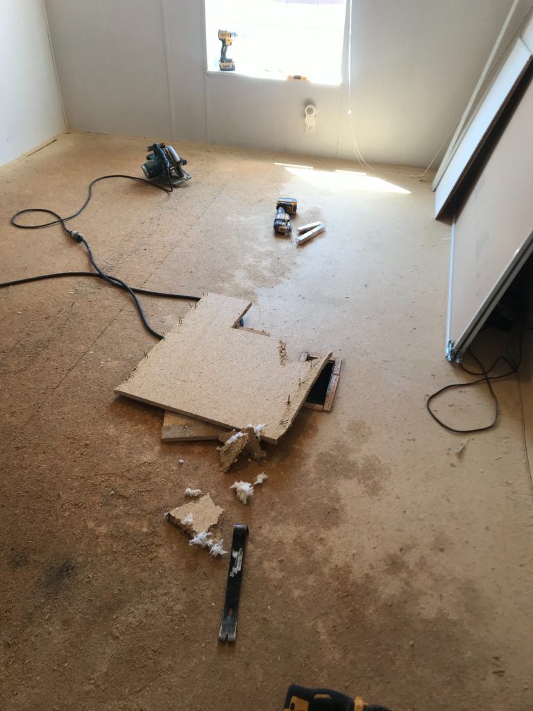 A room with a broken piece of wood on the floor.