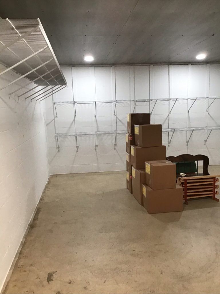 A room with a stack of cardboard boxes on the floor