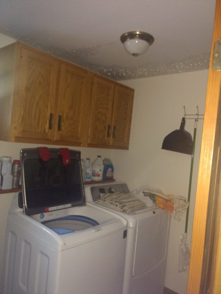 A water damaged laundry room with a washing machine and dryer.