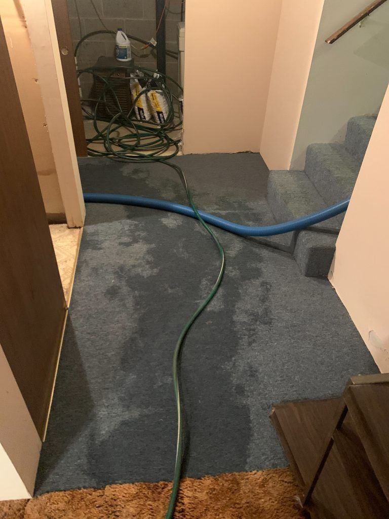 A blue hose is running through a hallway.