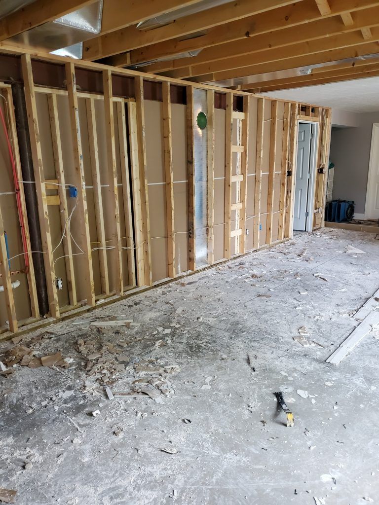 A room that is being remodeled with wooden walls and a concrete floor.