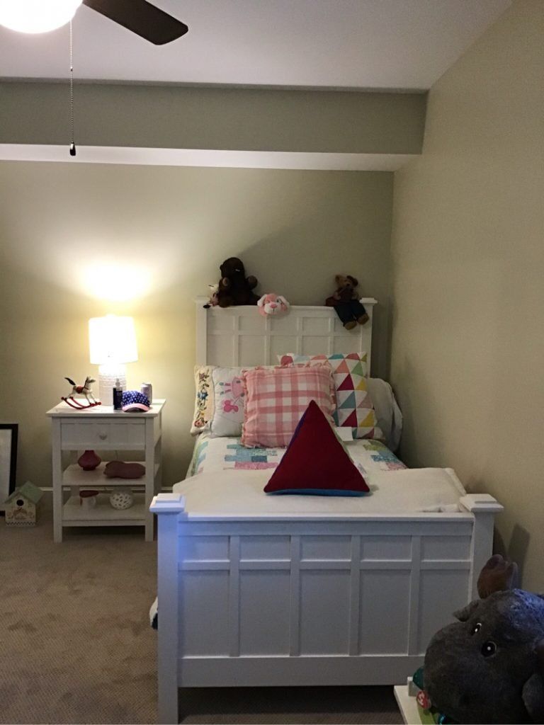 A bedroom with a bed, nightstand, lamp and ceiling fan.