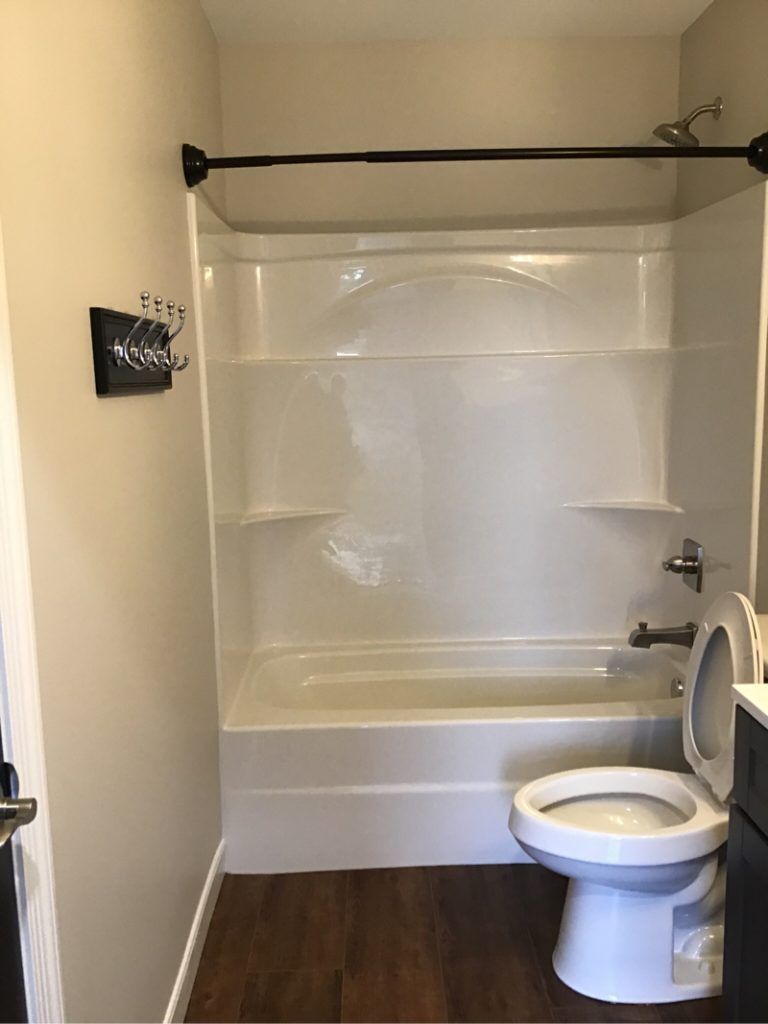 A bathroom with a toilet , bathtub and shower.