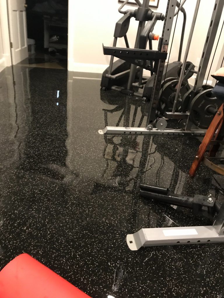 A gym with a black floor and a red mat