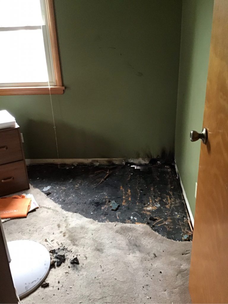 A fire damaged basement with a window.