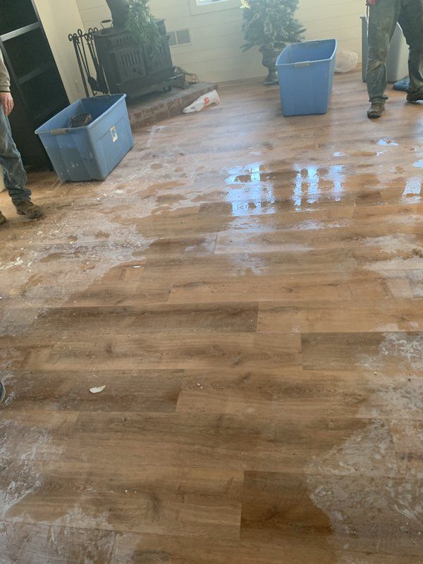 A person is standing on a wooden floor in a living room.