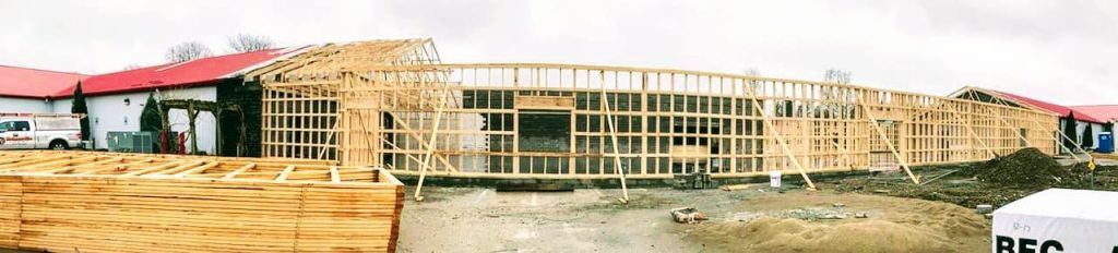 A large wooden structure is being built with a red roof.