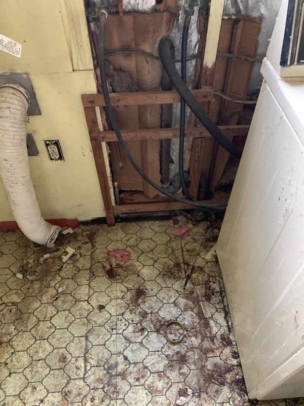 A dirty laundry room with a washer and dryer.