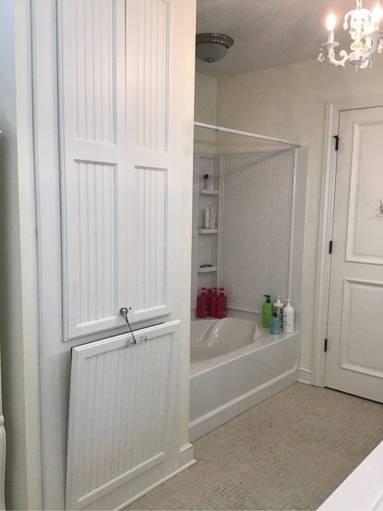 A bathroom with a tub , shower , and cabinets.