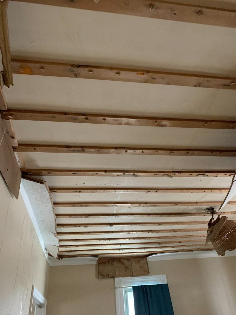 A room with a wooden ceiling and a window.