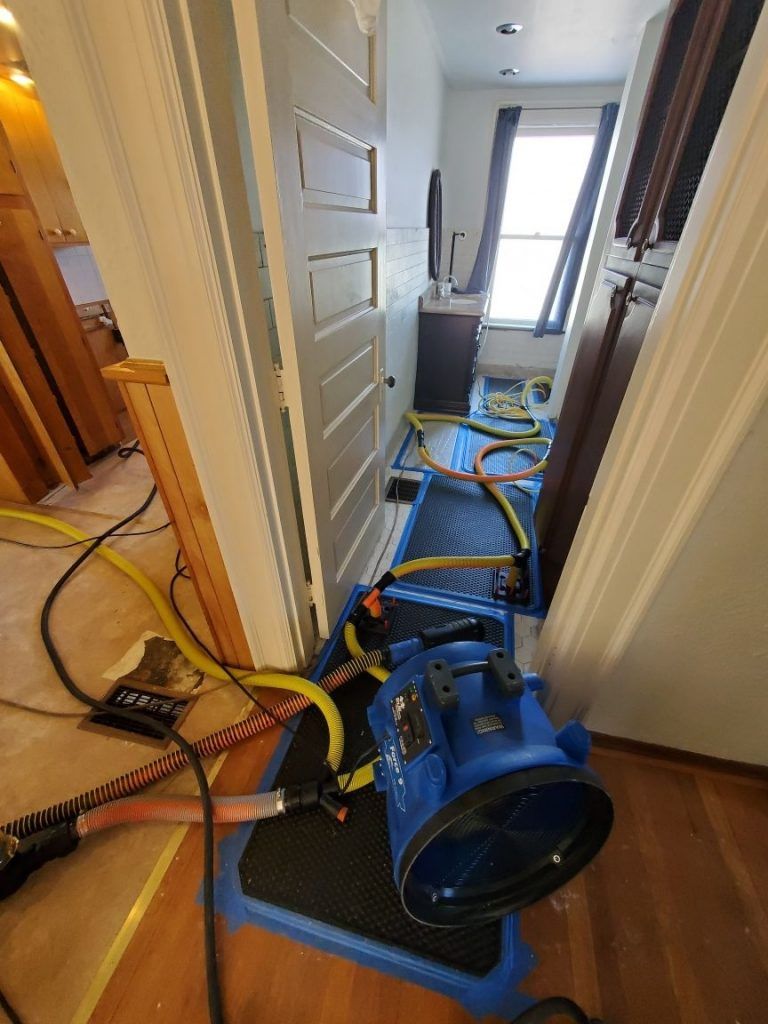 A room with a vacuum sitting on the floor next to a door.