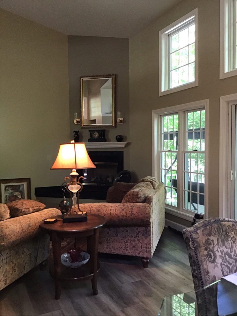 A living room with a table, couch, fireplace, and  lamp.