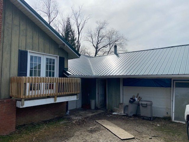 A house with a metal roof and a wooden deck.