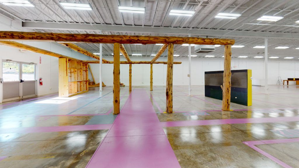A large empty warehouse with pink lines on the floor.