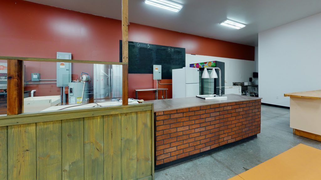 A room with a brick and wood island and red walls.