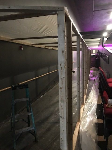 A ladder is sitting in the middle of a hallway.