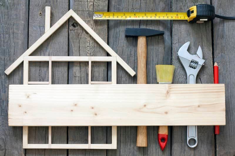 A wooden house with tools on a wooden table.