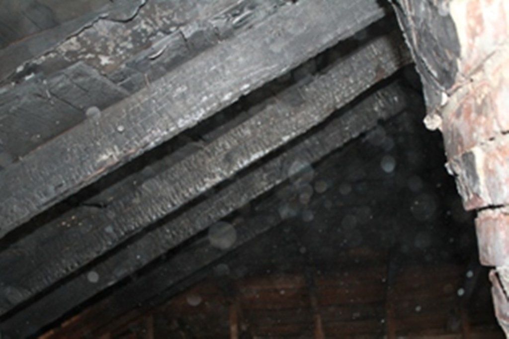 A dark room with a brick wall and wooden beams.