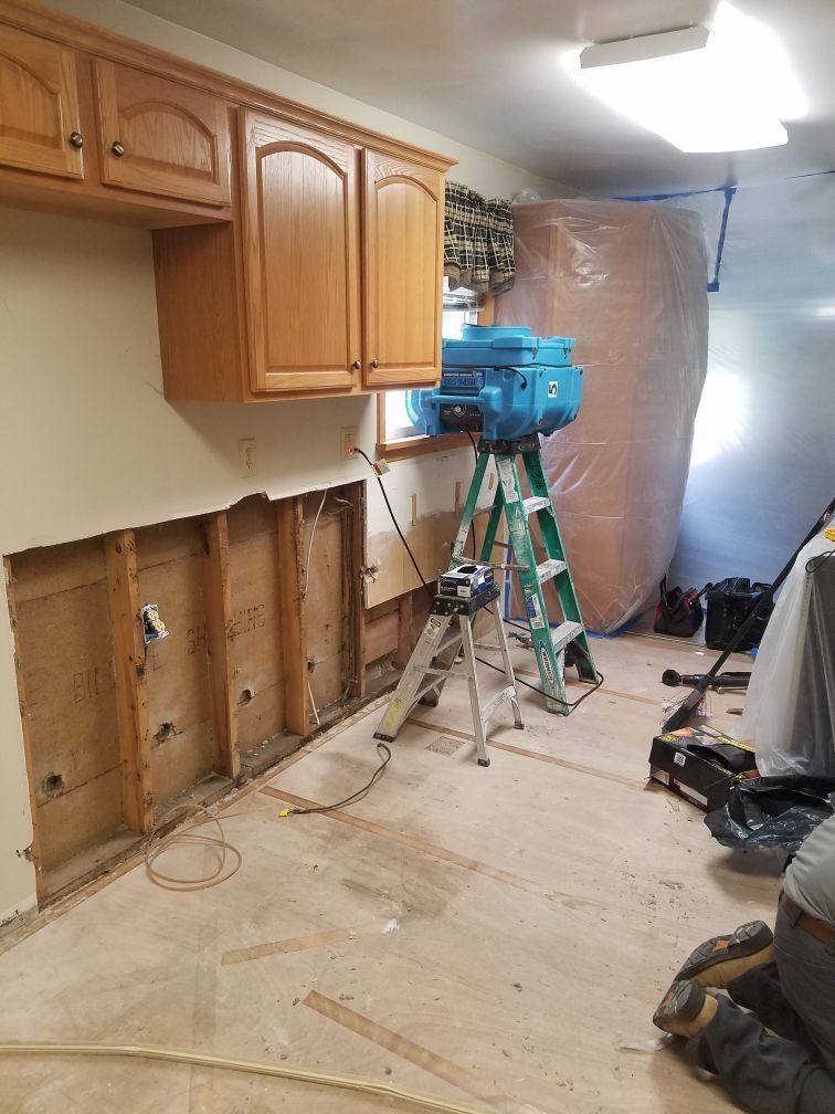 A room with wooden cabinets and a ladder in it.
