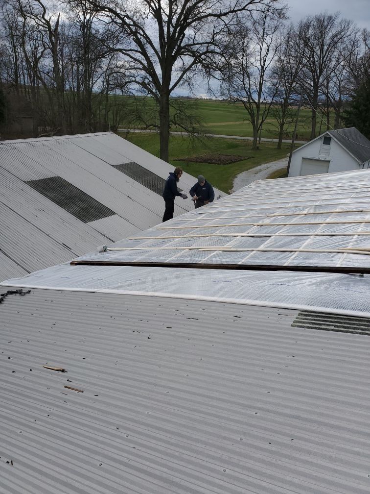 Two men are working on the roof of a building
