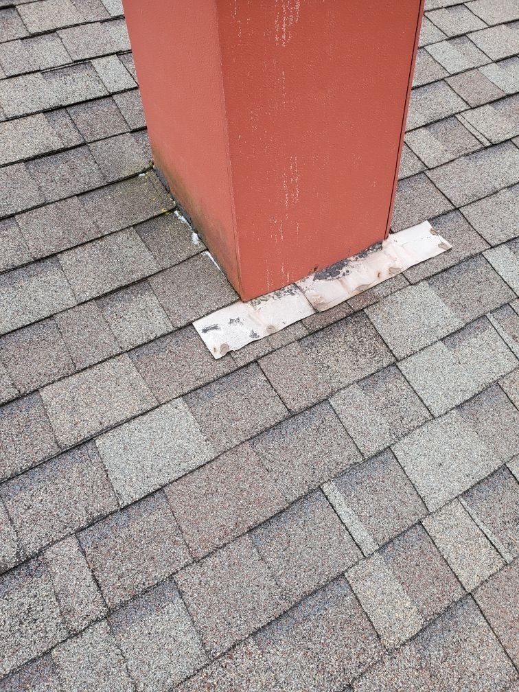 A red chimney is sitting on top of a roof.