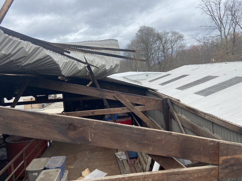 The roof of a building has been damaged by a storm.