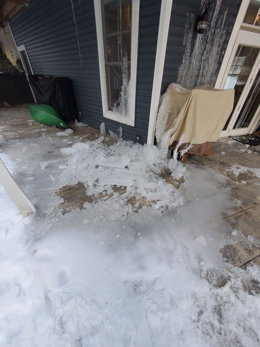 There is a lot of snow on the ground in front of a house.
