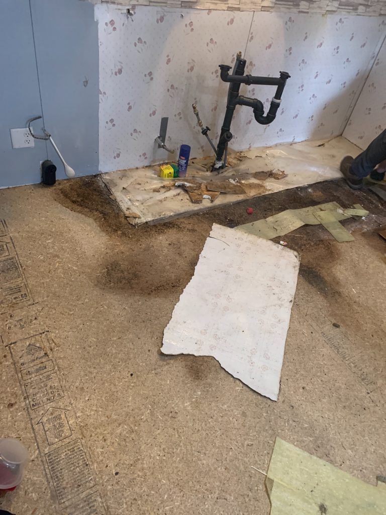 A person is working on a bathroom floor.