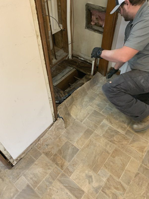 A man is kneeling on the floor in a room.