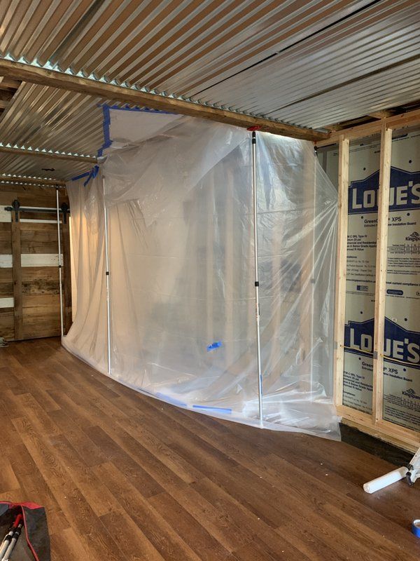 A room being repaired with plastic covering  over the wall frame.